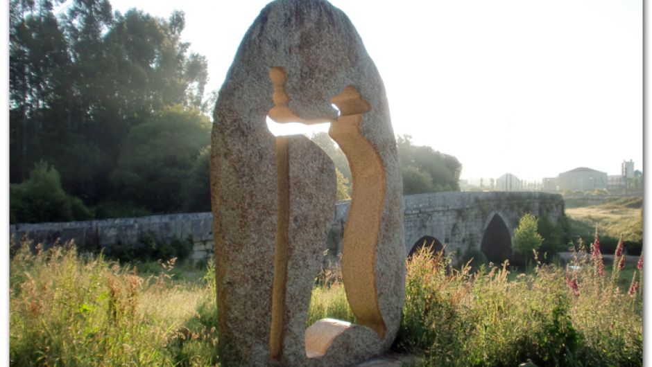 Monumento al peregrino y puente medieval sobre el río Louro