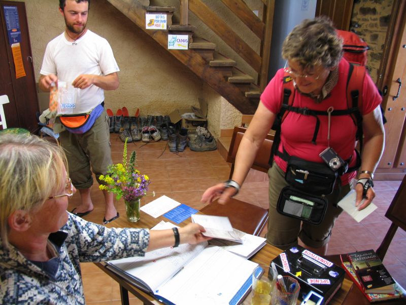 Hospitalera atendiendo a los peregrinos en el albergue parroquial de El Acebo (León)