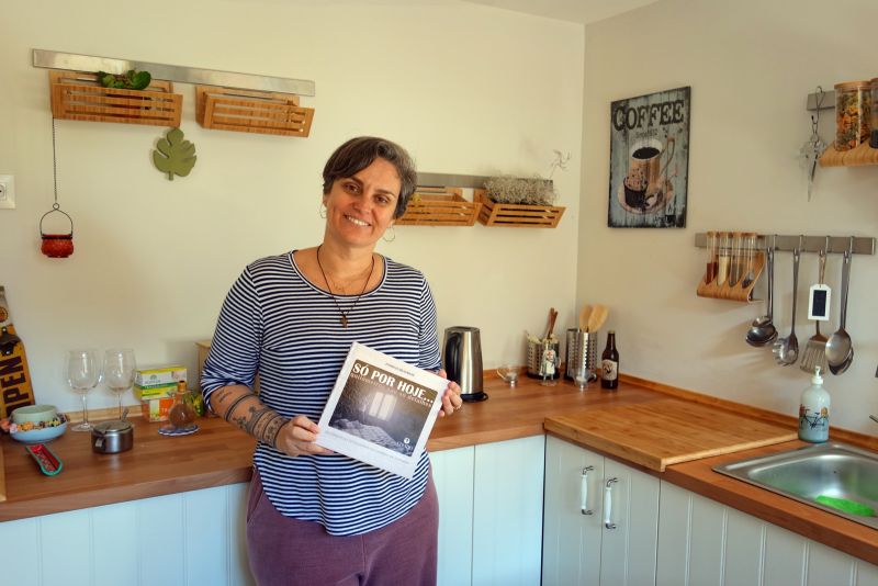 La brasileña Patrícia en la cocina de su albergue con su libro, Só por Hoje
