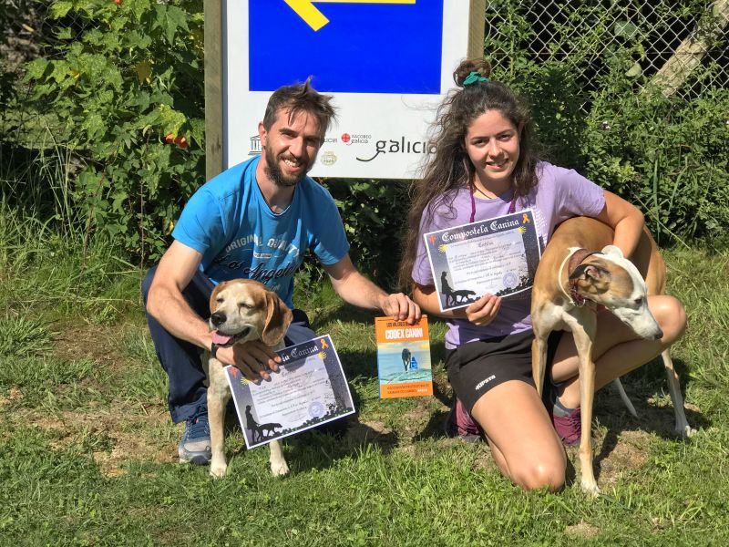 Perros con su Compostela canina, y el Codex Canini entre ambos.