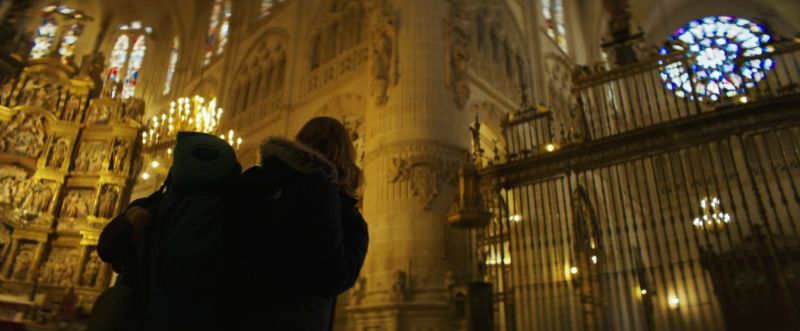 Jana, iluminándose en la catedral de Burgos con la mochila a la espalda.