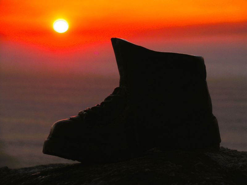 Puesta de sol con el monumento de la bota, Cabo Fisterra.