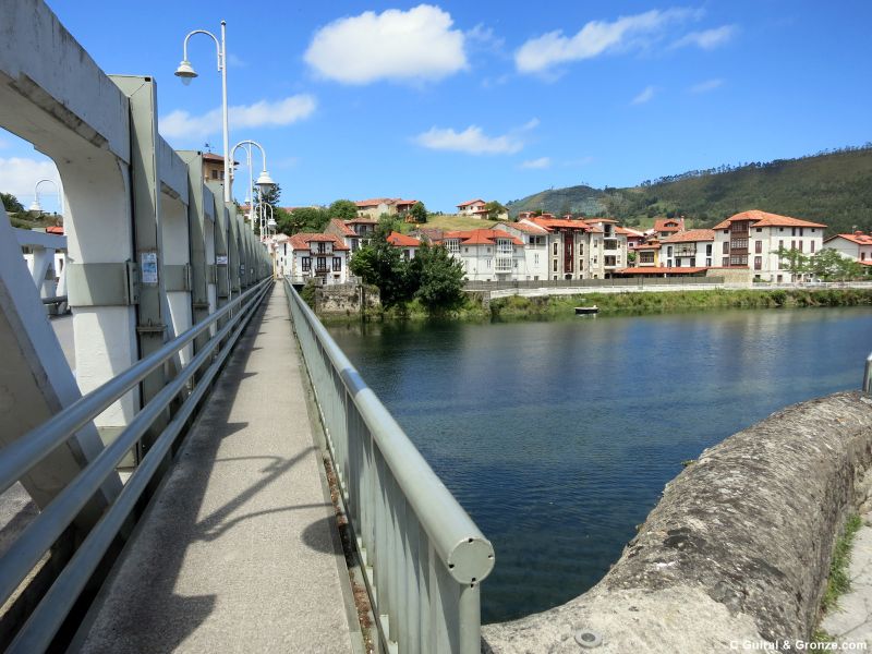 Puente sobre el río Deva y al fondo las casas de Bustio