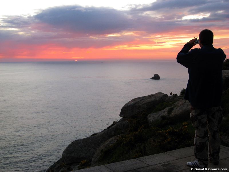 Peregrino fotografiando los últimos rayos de sol, cabo de Finisterre Peregrino fotografiando los últimos rayos de sol, cabo de Finisterre